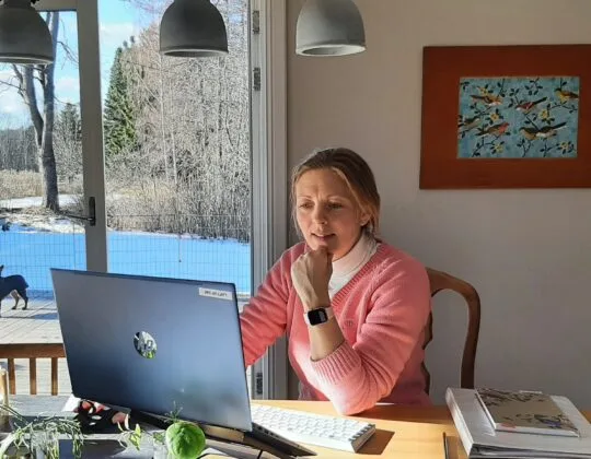 Petra på kansliet sitter och läser på en laptop, kanske sidan Prenumerera på Leader Bergslagens nyhetsbrev